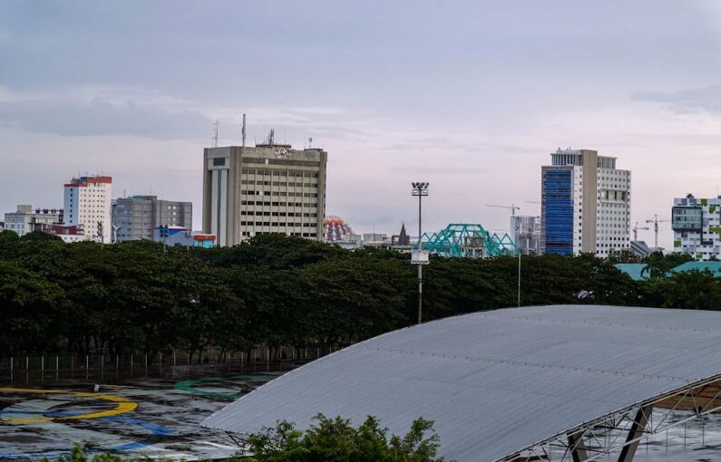 Makassar Urban - a bridge over a river with buildings in the background
